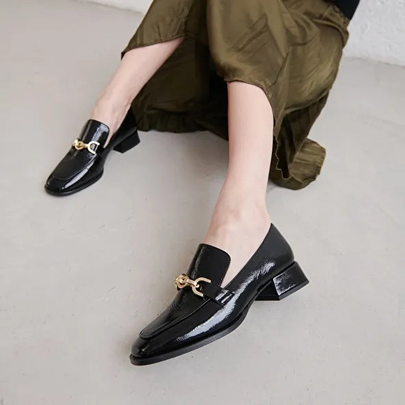 Loafers with gold buckles in black pleated patent